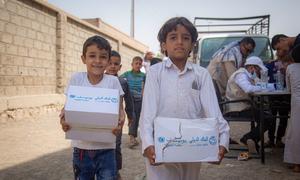 Displaced children carry hygiene kits distibuted by UNICEF in Marib, Yemen.